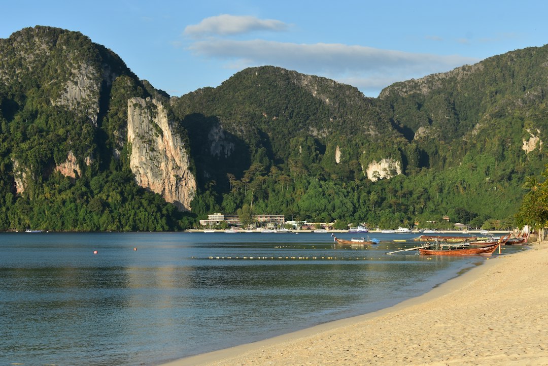 Plage et bateaux devant les falaises calcaires de Thaïlande